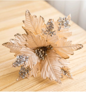 Detailed view of champagne velvet poinsettia with gold glitter edges and silver sequins
