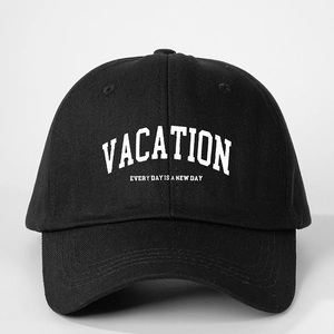 Detail of black cotton baseball cap featuring white VACATION text and vintage typography