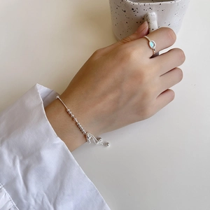 Minimalist S925 sterling silver beaded bracelet and blue gemstone ring on model's hand