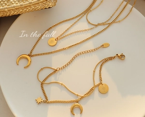 Detail of multi-layered gold celestial jewelry set with K18 stamp on moon pendants
