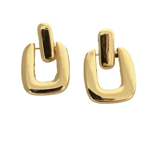 Detail of 18K gold plated geometric earrings with nested square design and glossy finish