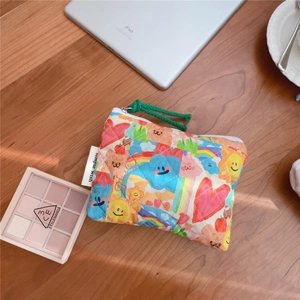 Detailed macro view of quilted cotton pouch with colorful cartoon graffiti and rope zipper