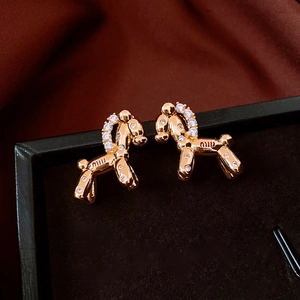 Macro shot of 18k gold plated balloon dog earrings with zircon inlays and miu engraving