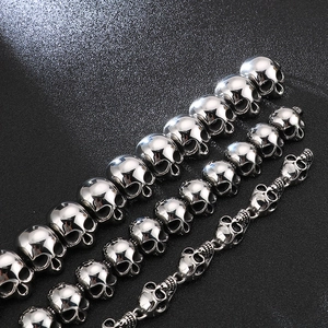 Detailed macro view of silver steel skull charms for men's biker jewelry bracelets