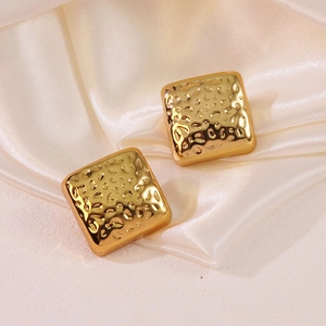 Elegant gold square geometric earrings with hammered texture on white silk background