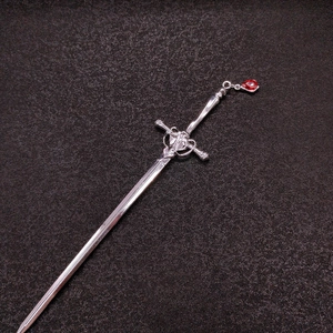 Detail of silver sword hair pin with red teardrop gem in ancient Chinese style