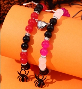 Close-up of magnetic heart clasp and black spider charms on beaded Halloween bracelets