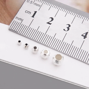 Macro shot of S925 sterling silver faceted beads with a ruler showing sizes from 2mm to 5mm