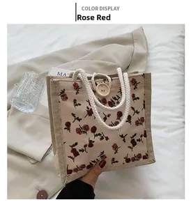 Detailed view of rose red floral tote bag featuring a natural wood button and woven handles