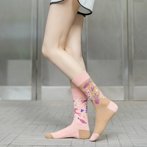 Detailed view of asymmetric cotton socks featuring pink unicorn and plant patterns