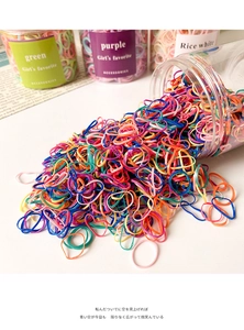 Colorful high-elastic disposable hair bands spilling from a transparent plastic jar