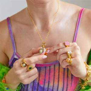 Detailed view of heart-shaped gold necklace pendant with colorful crystals on model