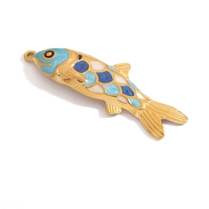 Macro shot of gold-plated fish pendant with blue and white enamel details and jump ring