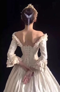 Detailed back view of wings hair clip with tassel on ivory satin gown silhouette