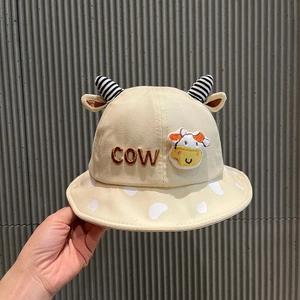 Detail of beige baby bucket hat featuring cow horn accents and embroidered COW logo