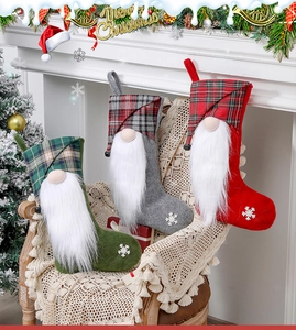 Three festive Christmas stockings with gnomes and snowflake embroidery on a cozy chair