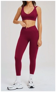 Dettaglio dei leggings da yoga a vita alta incrociata e del reggiseno sportivo bordeaux