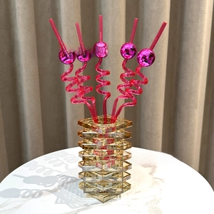 Detailed view of 5 pink spiral straws featuring mirror disco ball toppers on marble