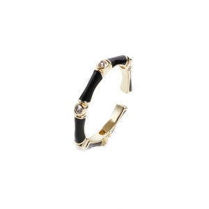 Detailed view of an adjustable bamboo-style ring with gold plating and black enamel inlay