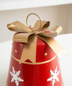 Close-up of red metal cone Christmas decoration with gold bow and white snowflake patterns