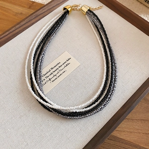 Detail view of multi-layer beaded necklace with black, white, and grey glass beads