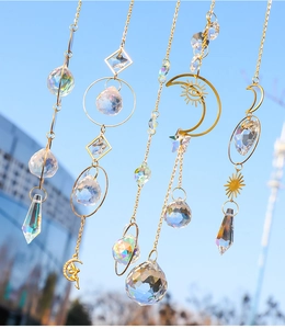 Close-up of golden sun catchers with crystals and moon motifs against a blue sky