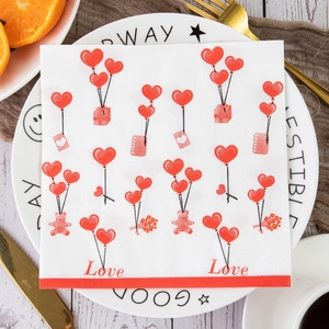 Close-up of Valentine's Day napkins with red heart patterns and teddy bear on a dinner plate