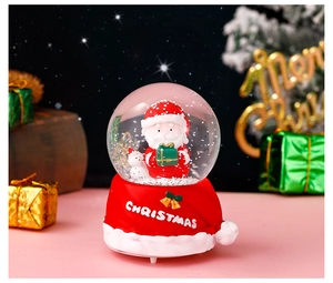 Detailed close-up of a Christmas snow globe with Santa Claus and red base ornament