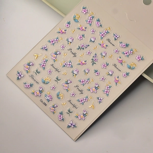 Macro detail of 3D embossed floral nail sticker with gold accents and purple flowers