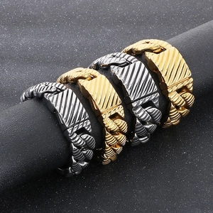 Detail of gold and silver cuban chain bracelets with diagonal textures on a pillar