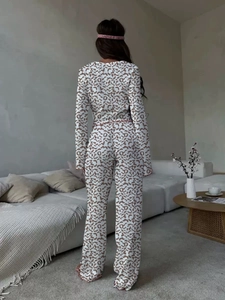 Detail view of leopard print loungewear featuring pink ruffled edges and soft knit fabric