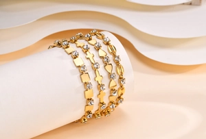 Detail of four-piece 18K gold plated bracelet set with zircon cross and heart charms