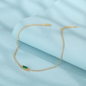 Close-up of golden S925 silver bracelet with marquise-cut green zircon gemstone