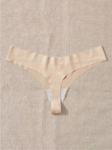 Detail of seamless nude thong with laser-cut edges on a soft textured background
