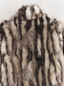 Close-up of black and white faux fur texture on back of stand collar plush coat