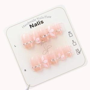 Pink gradient press-on nails with white cherry blossoms, pearls and rhinestone accents