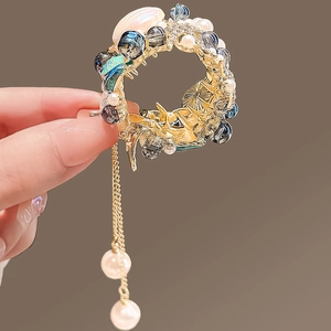 Épingle à cheveux éventail chinois doré avec perles pendantes et glands sur fond brun