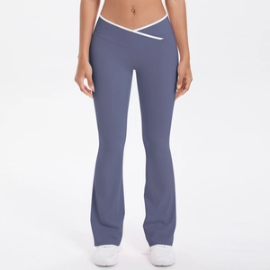Detail of high-waisted yoga pants with white V-cross waistband and flared leg in dusty blue