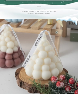 Close-up of Christmas tree scented candles with decorative Best Wishes silk ribbons