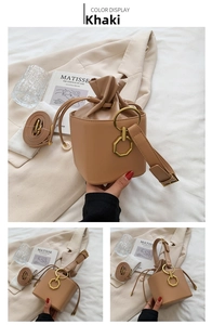 Detail of khaki bucket bag with drawstring closure and golden geometric charm