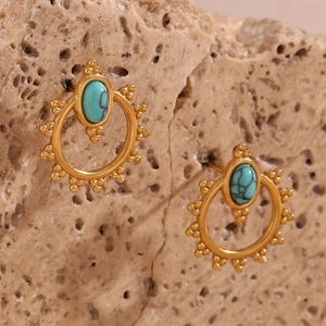 Detailed close-up of bohemian gold earrings with oval turquoise and beaded edges