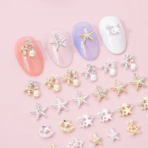 Close-up of alloy starfish and seashell nail art studs with pearls and rhinestones