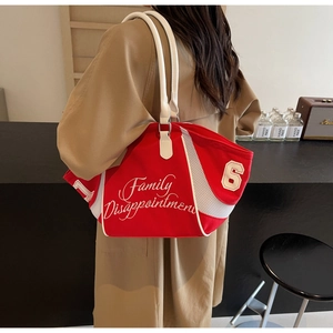 Detailed view of red canvas bowling bag with white embroidery and mesh paneling