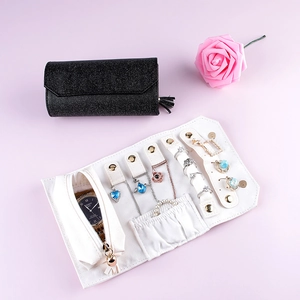 Portable travel jewelry roll organizer in black sequin and white textured finishes