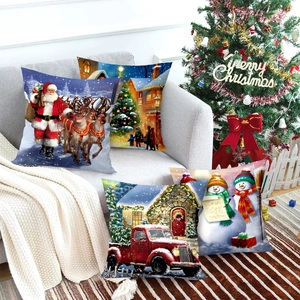 Set of four Christmas pillow covers with Santa and red truck on a modern sofa