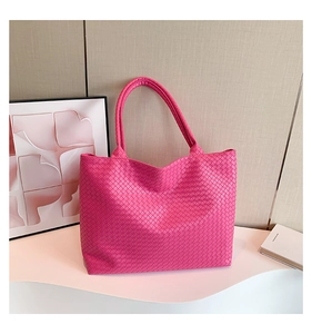 Detail of fuchsia woven leather tote bag texture on a white decorative display stand