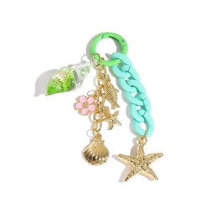 Détail du porte-clés thème marin avec chaîne en acrylique vert et breloques dorées
