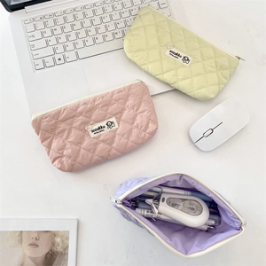 Macro view of quilted pastel makeup bags and stationery pouches with zipper detail
