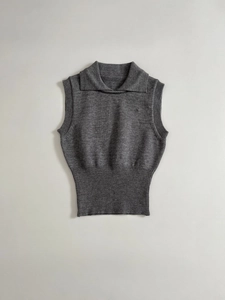 Detail of grey knitted vest showing refined lapel collar and ribbed hem texture