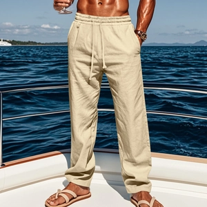 Detail of men's beige linen trousers featuring a drawstring waist on a yacht